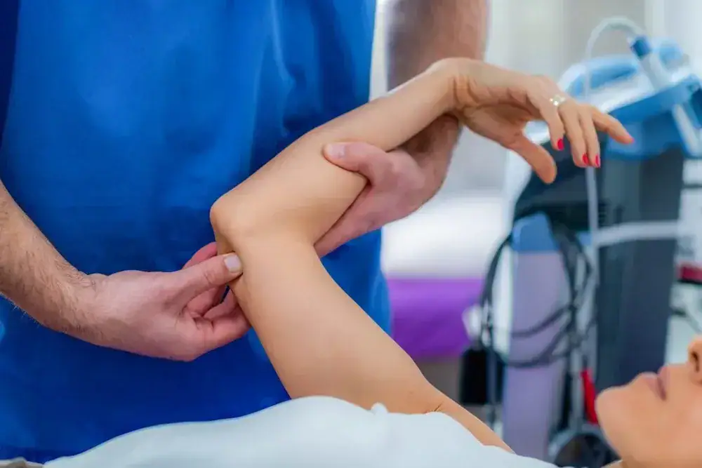 Physical therapist helping a patient with arm rehabilitation.